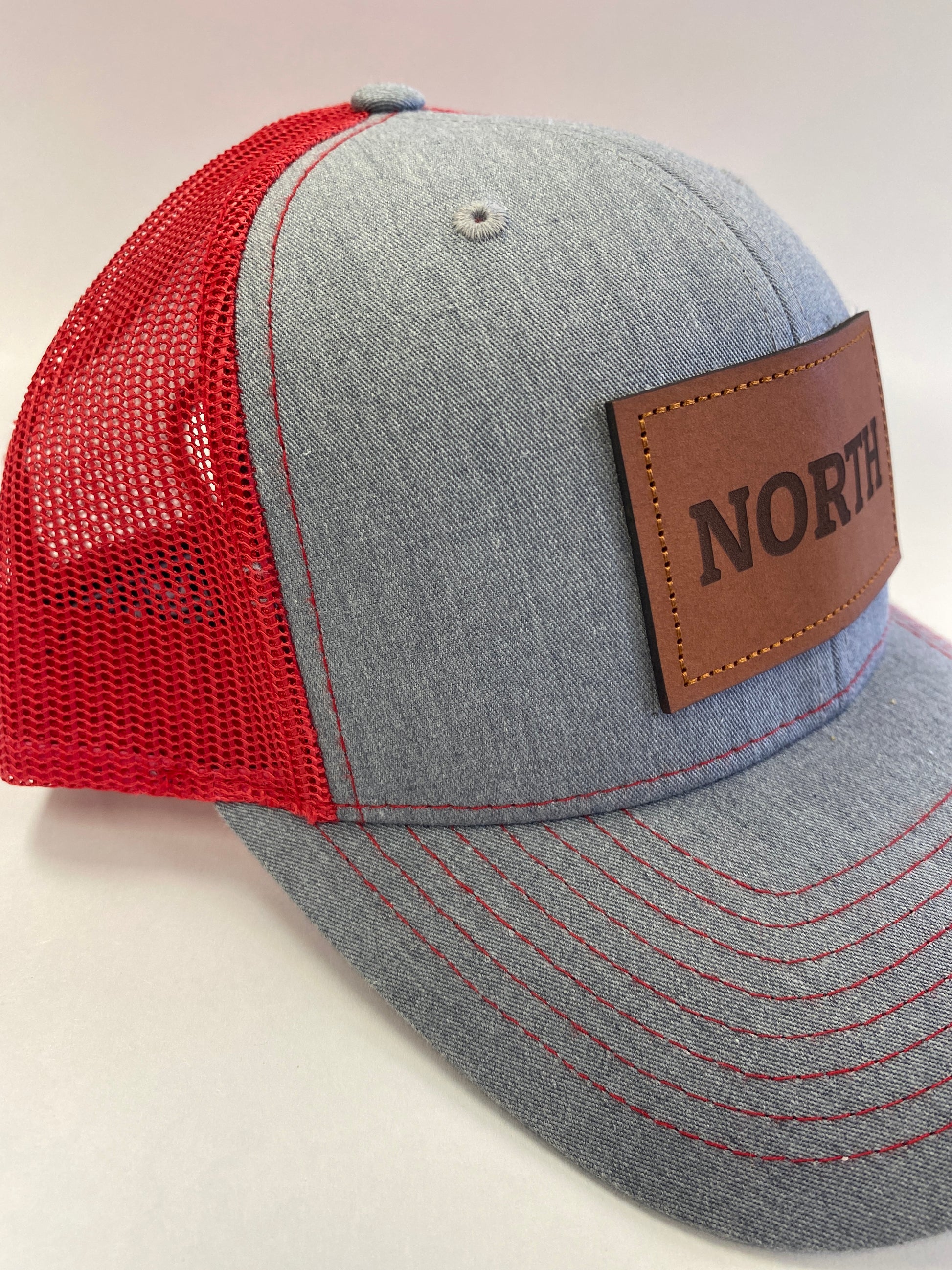 Leather Patch NORTH Trucker Hat in heather gray/red mesh